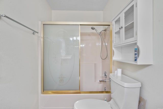 bathroom featuring a textured ceiling, toilet, and bath / shower combo with glass door