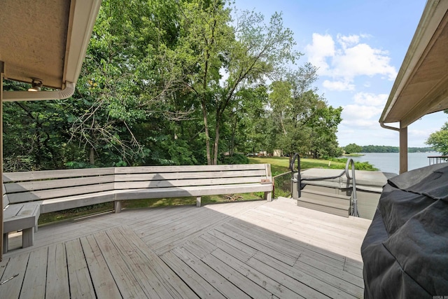 wooden terrace with area for grilling and a water view