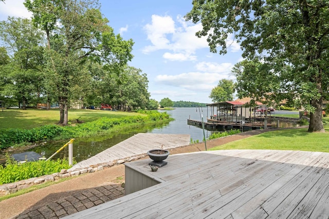 dock area with a lawn and a water view