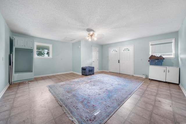 unfurnished room featuring ceiling fan and a textured ceiling