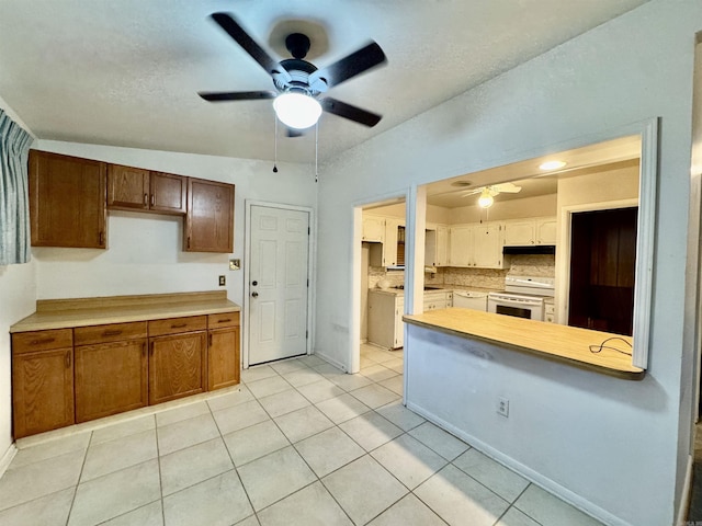 kitchen with light tile patterned floors, ceiling fan, backsplash, electric stove, and lofted ceiling