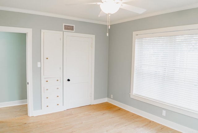 unfurnished bedroom with ceiling fan, a closet, light wood-type flooring, and ornamental molding