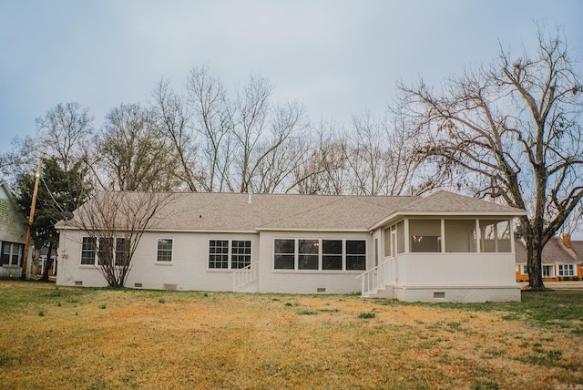 rear view of house with a sunroom and a lawn