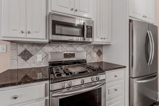 kitchen featuring dark stone countertops, decorative backsplash, stainless steel appliances, and white cabinets