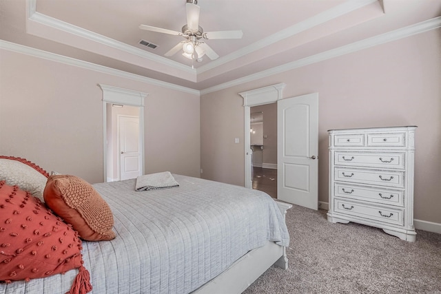 bedroom with a tray ceiling, ornamental molding, ceiling fan, and carpet flooring