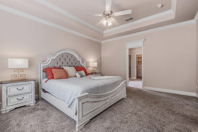 carpeted bedroom with crown molding, ceiling fan, and a tray ceiling