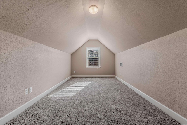 additional living space with carpet floors and vaulted ceiling