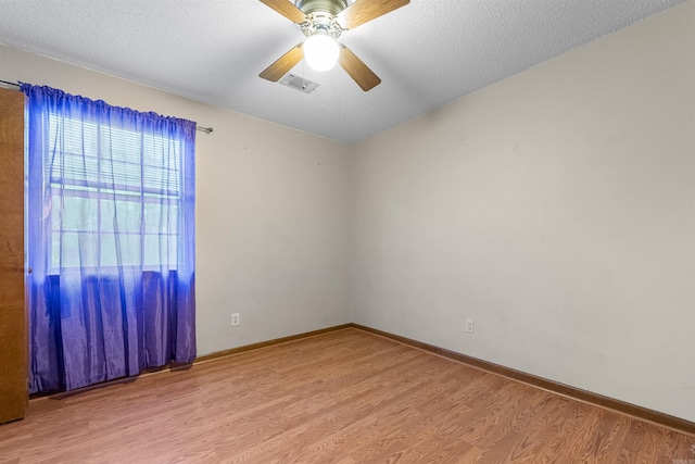 spare room with ceiling fan, a textured ceiling, and hardwood / wood-style flooring