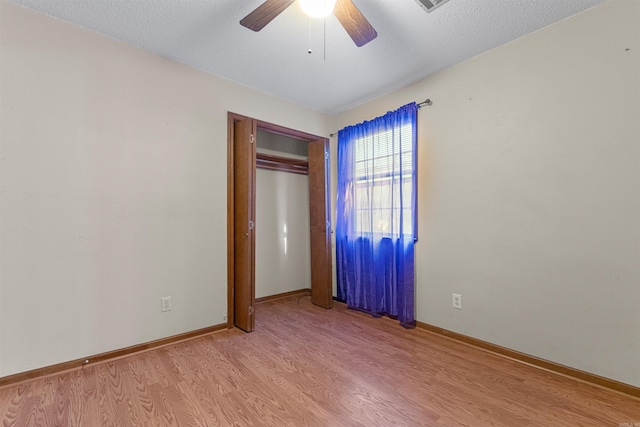 unfurnished bedroom with light wood-type flooring, a closet, and ceiling fan