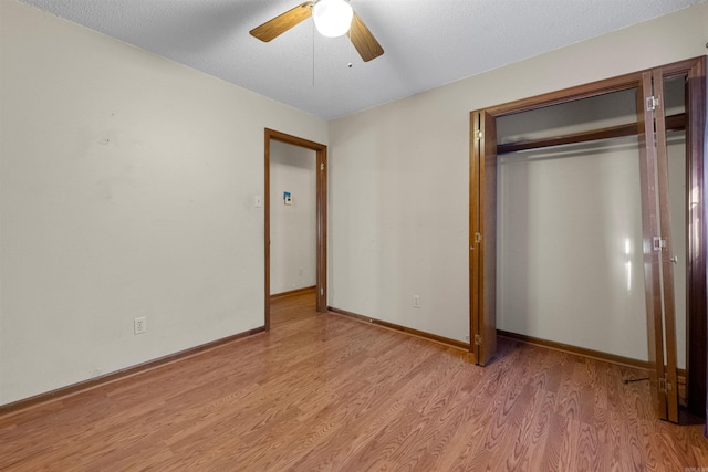 unfurnished bedroom with ceiling fan, light wood-type flooring, and a closet