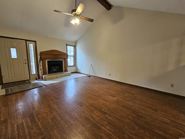 unfurnished living room with lofted ceiling with beams, hardwood / wood-style flooring, ceiling fan, and a tiled fireplace