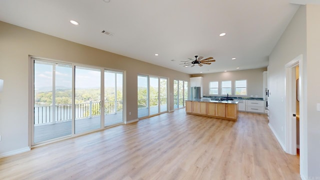 kitchen featuring ceiling fan, white cabinetry, a wealth of natural light, and light hardwood / wood-style flooring