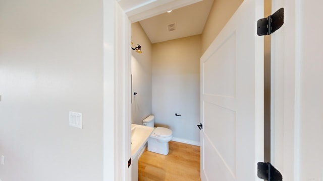 bathroom featuring wood-type flooring and toilet