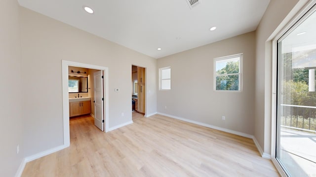 unfurnished bedroom with sink, access to exterior, light hardwood / wood-style flooring, and ensuite bath