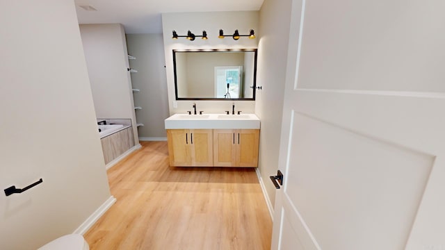 bathroom featuring a bath, vanity, and hardwood / wood-style floors