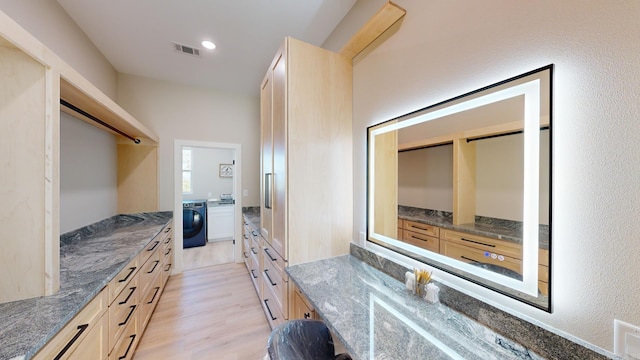 bathroom with washer / dryer and hardwood / wood-style floors