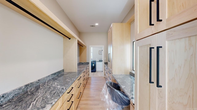 corridor featuring washer / dryer and light hardwood / wood-style flooring