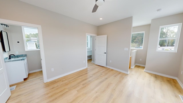 bedroom with ceiling fan, light hardwood / wood-style floors, and a walk in closet