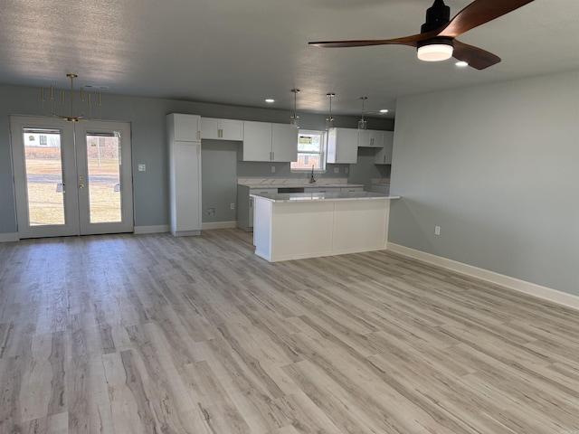 kitchen with white cabinets, decorative light fixtures, light hardwood / wood-style flooring, and ceiling fan