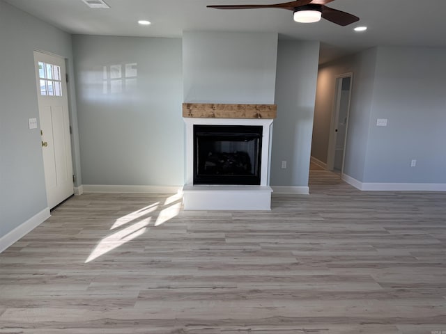 unfurnished living room with ceiling fan and light hardwood / wood-style flooring