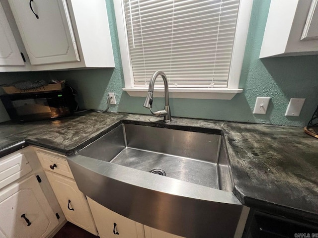 kitchen featuring white cabinetry and sink