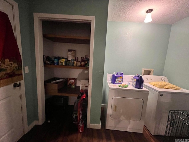 laundry room with a textured ceiling, washing machine and dryer, and dark wood-type flooring