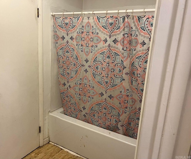 bathroom featuring hardwood / wood-style floors and shower / bath combo