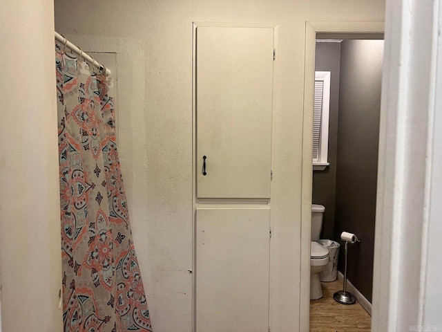 bathroom with curtained shower and toilet