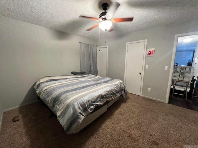 bedroom featuring dark colored carpet, a textured ceiling, and ceiling fan