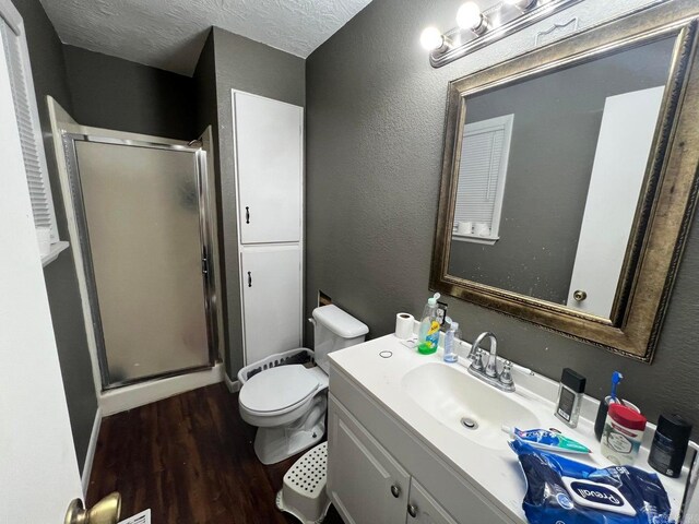 bathroom featuring hardwood / wood-style flooring, vanity, a textured ceiling, and walk in shower