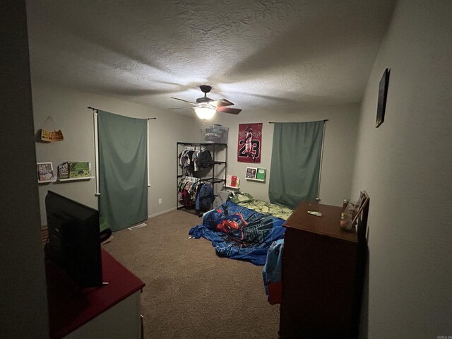 carpeted bedroom featuring a textured ceiling and ceiling fan