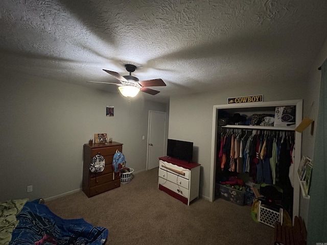 carpeted bedroom with ceiling fan, a textured ceiling, and a closet