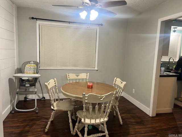 dining space featuring a textured ceiling, dark hardwood / wood-style floors, ceiling fan, and sink