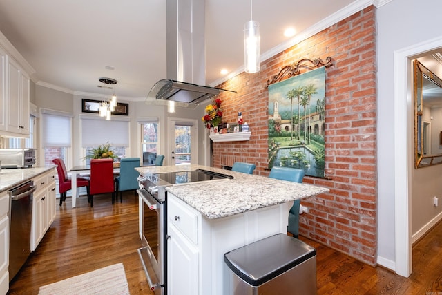 kitchen featuring decorative light fixtures, a kitchen bar, a center island, and appliances with stainless steel finishes