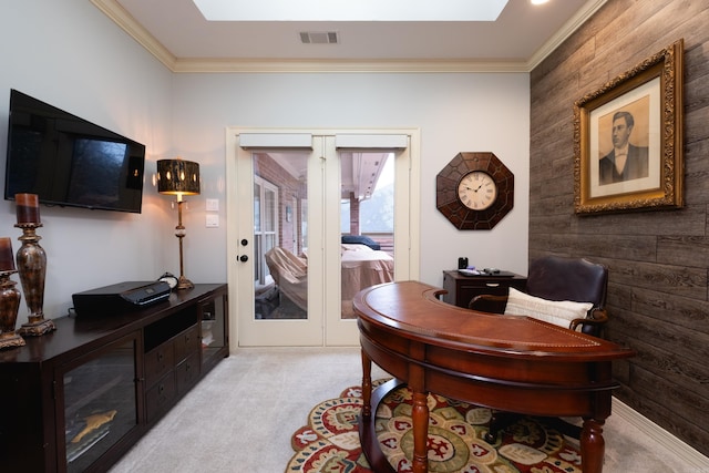 carpeted home office with wood walls, french doors, and ornamental molding