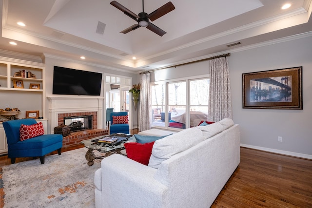 living room featuring a raised ceiling, crown molding, and dark hardwood / wood-style floors