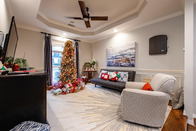 sitting room with crown molding, ceiling fan, and a tray ceiling