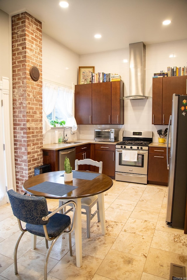 kitchen with dark brown cabinetry, sink, wall chimney exhaust hood, decorative backsplash, and appliances with stainless steel finishes