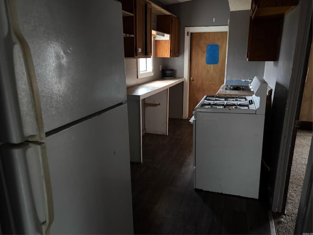 kitchen featuring dark hardwood / wood-style flooring, white appliances, and extractor fan