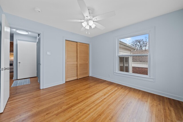 unfurnished bedroom with a closet, light hardwood / wood-style floors, and ceiling fan