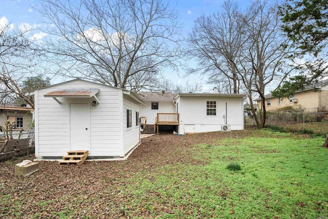 back of house featuring a wooden deck and a yard