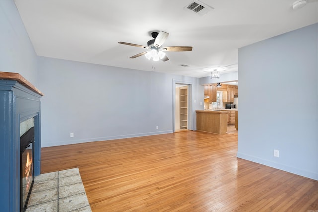 unfurnished living room featuring ceiling fan and light hardwood / wood-style floors