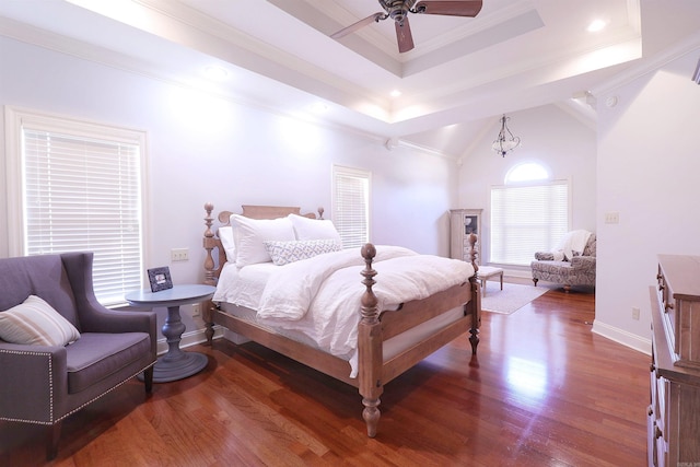 bedroom with ceiling fan, dark hardwood / wood-style floors, a raised ceiling, and ornamental molding