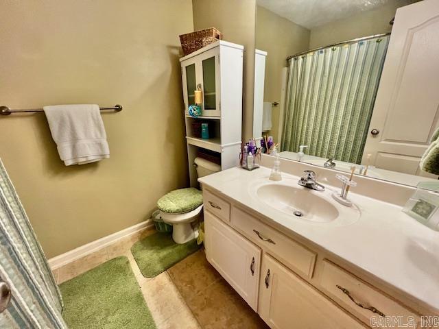 bathroom featuring tile patterned floors, vanity, and toilet