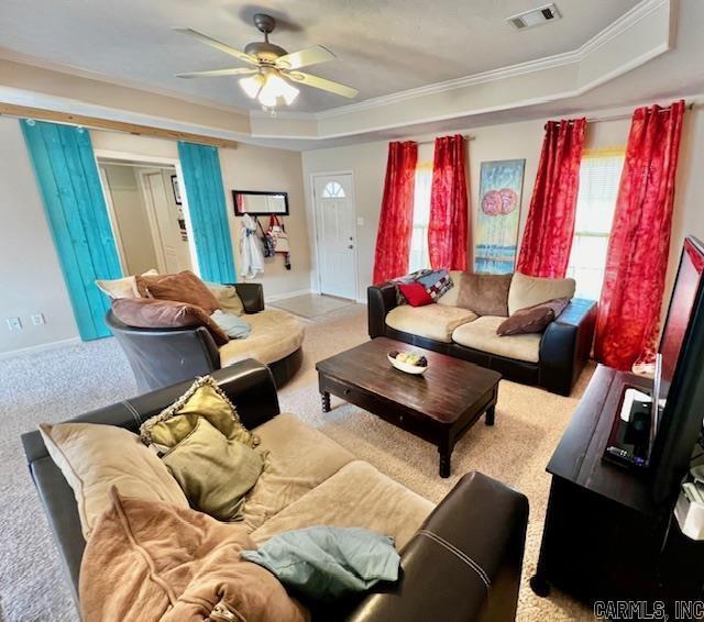 carpeted living room featuring ceiling fan, crown molding, and a tray ceiling