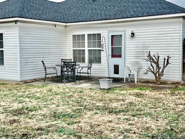 back of property featuring a yard and a patio