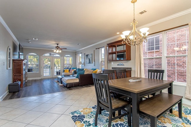 dining space featuring french doors, light tile patterned floors, a healthy amount of sunlight, and ornamental molding