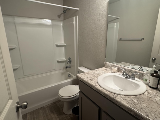 full bathroom with hardwood / wood-style flooring, bathing tub / shower combination, vanity, and toilet