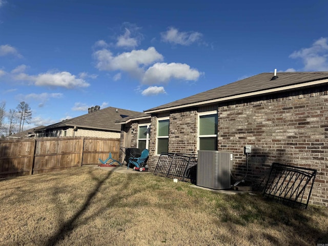 back of house with a lawn and central air condition unit