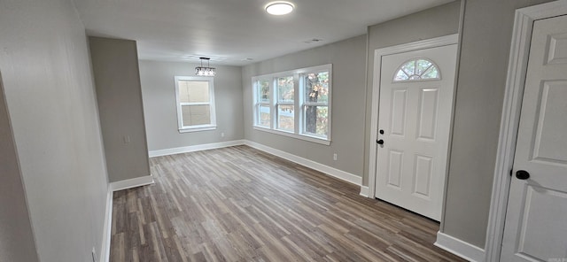 foyer with hardwood / wood-style floors, plenty of natural light, and an inviting chandelier